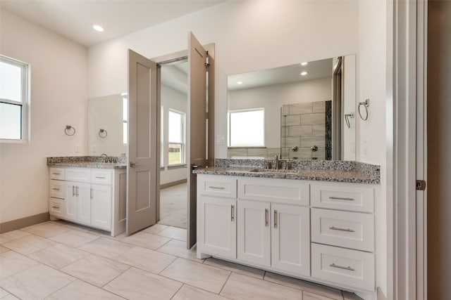 bathroom with a shower, tile patterned flooring, and vanity