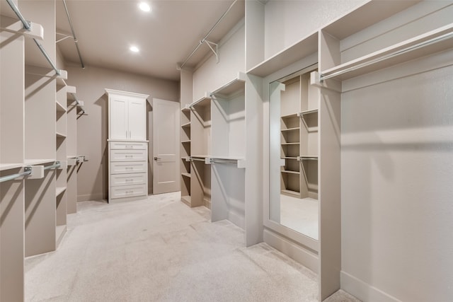 walk in closet featuring light carpet