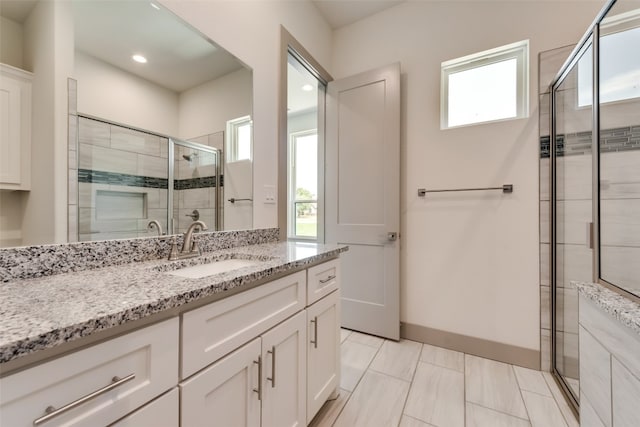 bathroom featuring tile patterned floors, a shower with door, and vanity