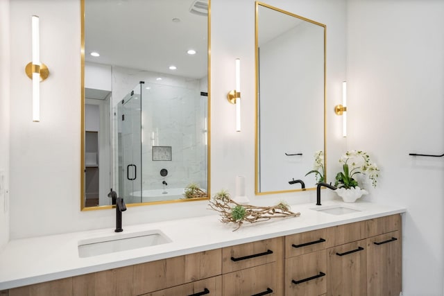 bathroom with vanity and a shower with door