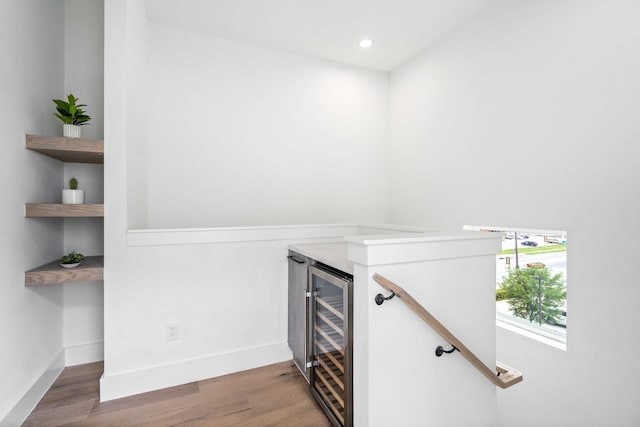 bar with hardwood / wood-style flooring and beverage cooler