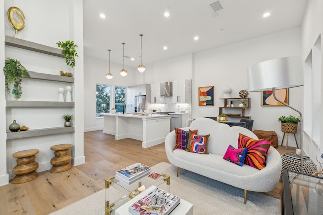 living room with light hardwood / wood-style flooring and sink