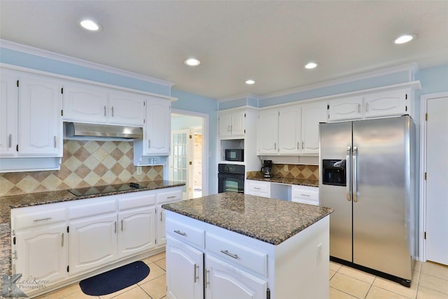 kitchen with wall chimney range hood, a center island, backsplash, white cabinetry, and black appliances