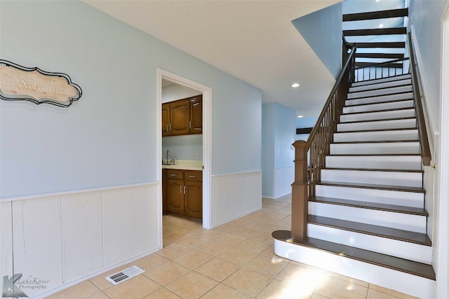 stairway with sink and light tile floors