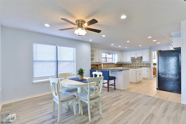 dining space with a textured ceiling, light hardwood / wood-style floors, and ceiling fan