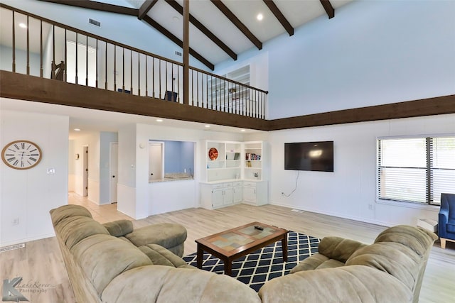 living room featuring beam ceiling, high vaulted ceiling, and light hardwood / wood-style floors