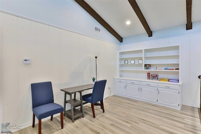 living area featuring built in features, lofted ceiling with beams, and light hardwood / wood-style floors