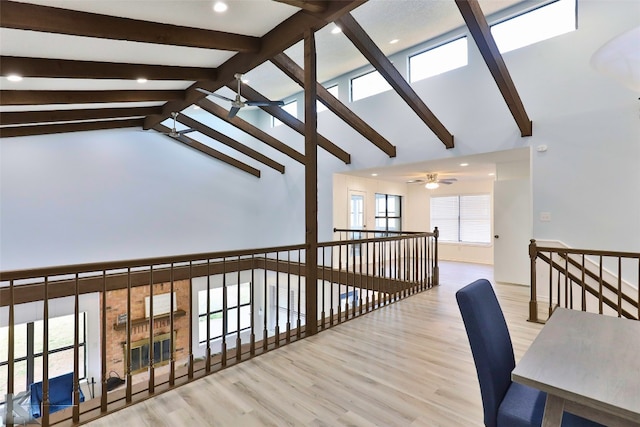 hall with vaulted ceiling with beams and light hardwood / wood-style floors