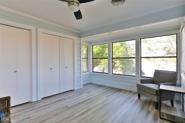 living area with ornamental molding, ceiling fan, and light hardwood / wood-style flooring