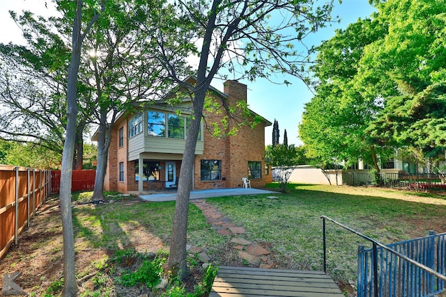 back of house with a patio and a yard