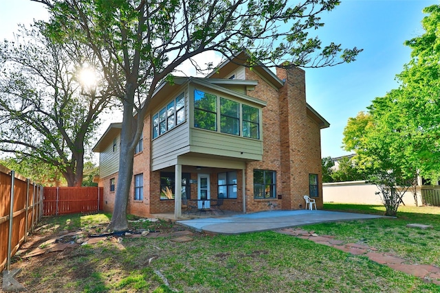 rear view of house with a patio area and a yard