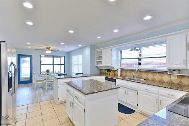 kitchen with backsplash, sink, a center island, and light tile floors