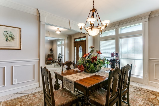 dining area with light tile patterned floors, crown molding, and a chandelier