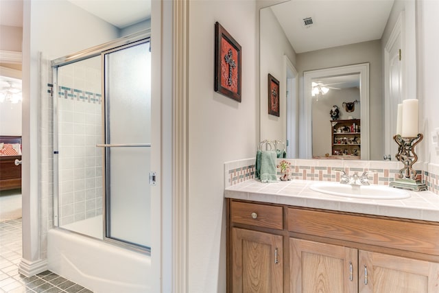 bathroom featuring tasteful backsplash, vanity, enclosed tub / shower combo, tile patterned flooring, and ceiling fan