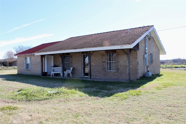 back of property with a lawn and covered porch