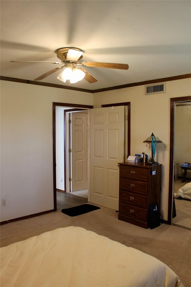 carpeted bedroom with ceiling fan and ornamental molding