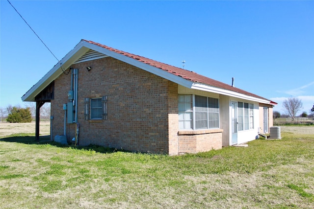 view of property exterior with a lawn and central air condition unit