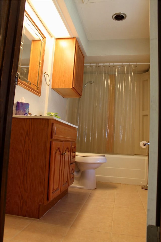 full bathroom featuring tile patterned flooring, vanity, toilet, and shower / bath combo with shower curtain