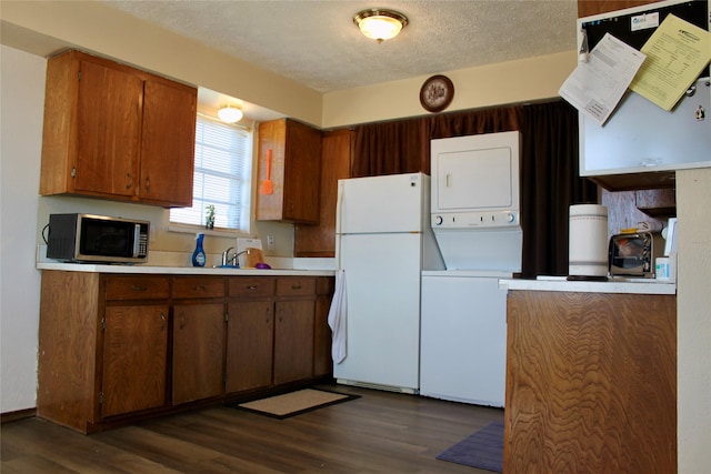 kitchen with dark hardwood / wood-style floors, white refrigerator, a textured ceiling, and stacked washer and clothes dryer