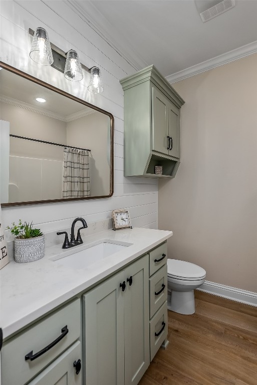 bathroom featuring hardwood / wood-style floors, toilet, vanity, and ornamental molding