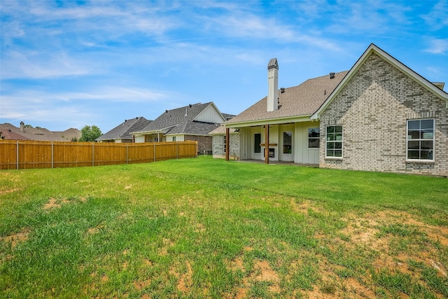 rear view of property with a yard