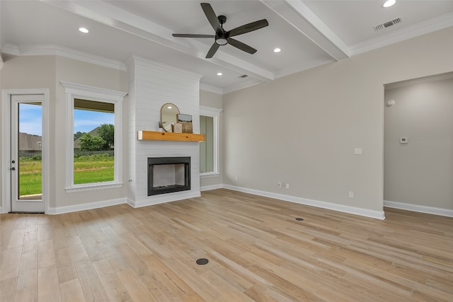 unfurnished living room featuring crown molding, light wood-type flooring, a large fireplace, ceiling fan, and beam ceiling