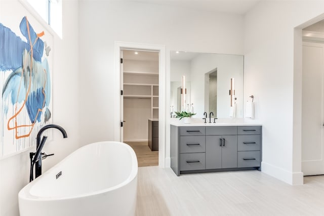 bathroom featuring a bathing tub, vanity with extensive cabinet space, and tile flooring