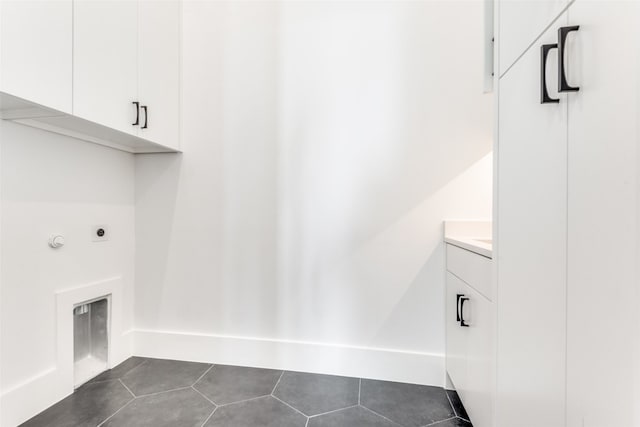 laundry area with cabinets, hookup for an electric dryer, dark tile floors, and hookup for a gas dryer