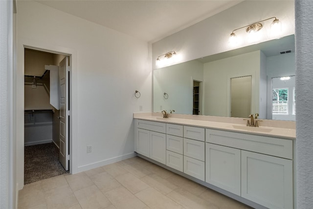 bathroom featuring tile floors, vanity with extensive cabinet space, and double sink