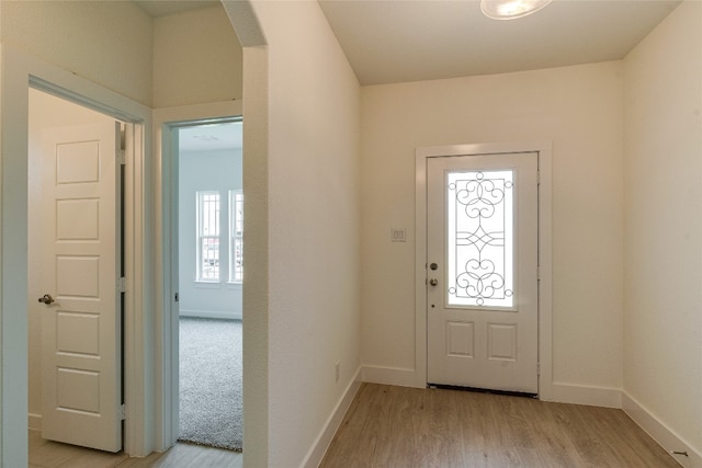 entrance foyer featuring light colored carpet and a healthy amount of sunlight