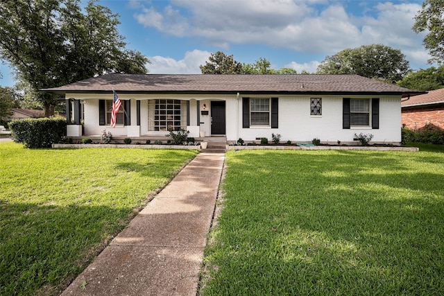 ranch-style home featuring covered porch and a front yard