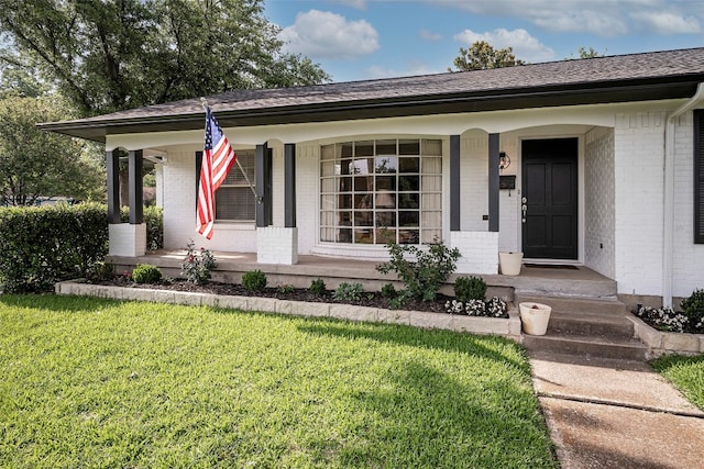 ranch-style house with a front yard and covered porch