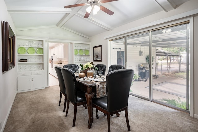 carpeted dining area featuring lofted ceiling with beams, ceiling fan, and built in features