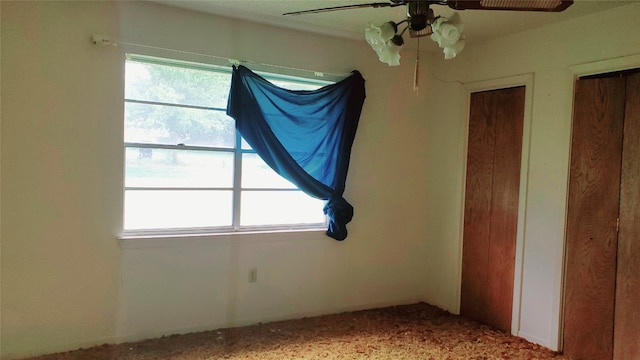 unfurnished bedroom with light carpet, ceiling fan, and multiple windows