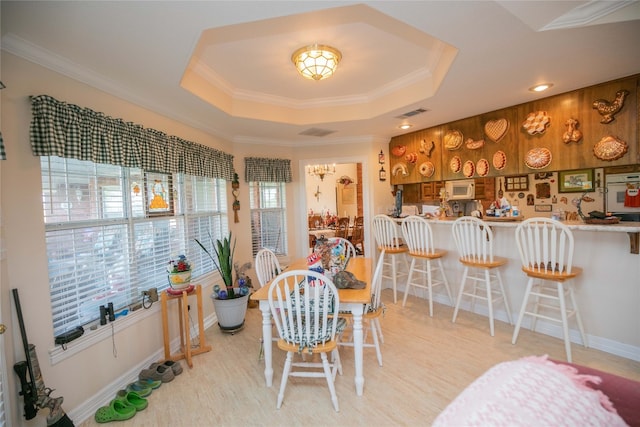 dining space with crown molding and a raised ceiling