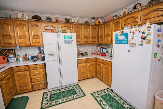 kitchen featuring white fridge with ice dispenser, white refrigerator, ornamental molding, and backsplash