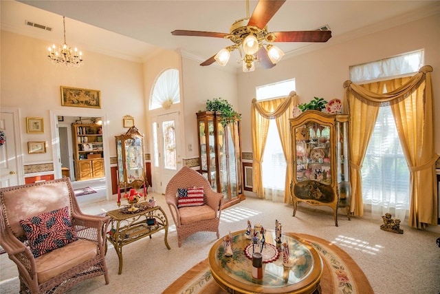 living area featuring ceiling fan with notable chandelier, light colored carpet, and a healthy amount of sunlight