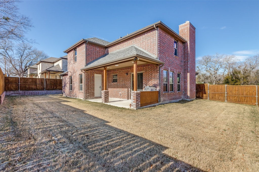 back of property with a lawn and a patio area