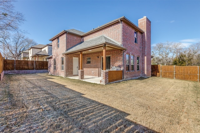 back of property with a lawn and a patio area