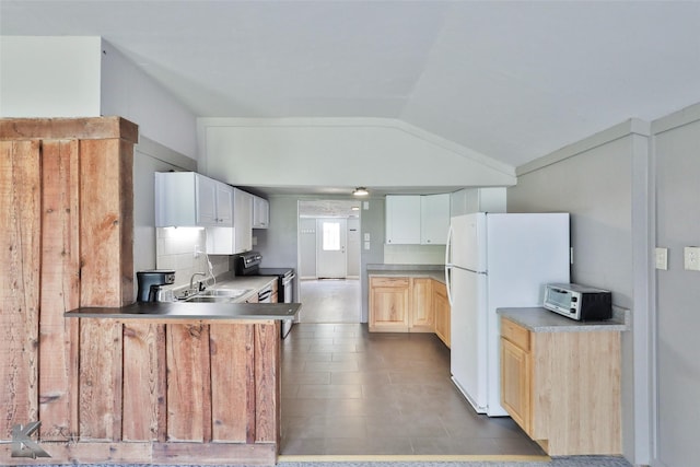 kitchen featuring lofted ceiling, sink, white refrigerator, kitchen peninsula, and stainless steel electric range