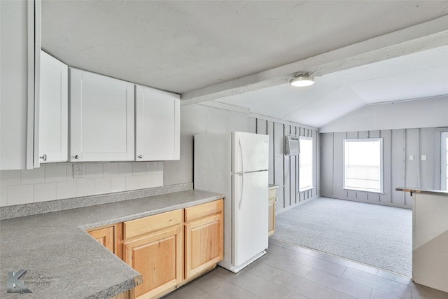 kitchen with vaulted ceiling with beams, backsplash, white refrigerator, light brown cabinets, and light colored carpet