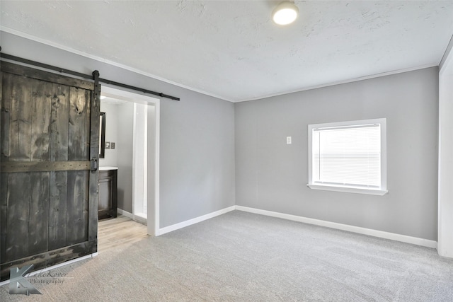 interior space featuring a barn door, crown molding, light carpet, and a textured ceiling