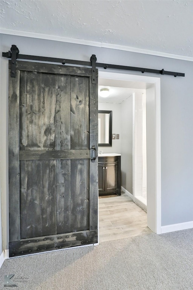 interior space featuring a textured ceiling, light carpet, and a barn door