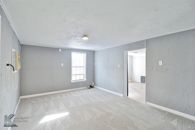 carpeted spare room featuring a textured ceiling and ornamental molding