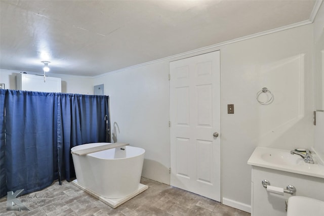 bathroom with ornamental molding, vanity, and a bathing tub