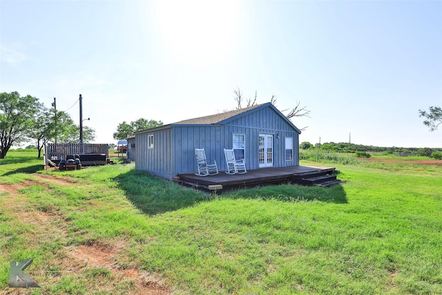 back of property featuring a deck and a yard