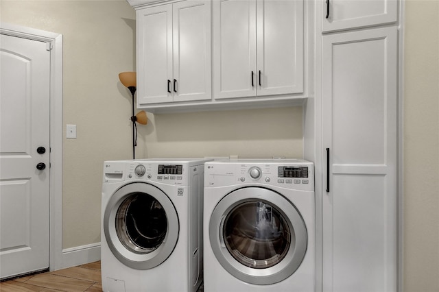 washroom with cabinets and washing machine and dryer