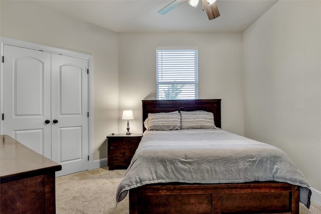 bedroom with ceiling fan, a closet, and light colored carpet