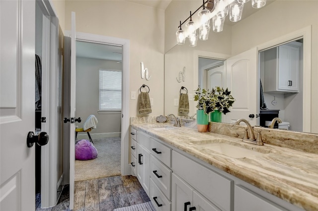 bathroom with hardwood / wood-style floors, dual sinks, and vanity with extensive cabinet space