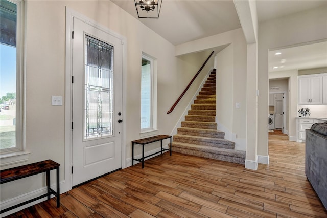 entryway featuring a notable chandelier, a healthy amount of sunlight, and light wood-type flooring